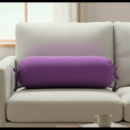 Purple cylindrical pillow on a light gray sofa with a blurred background