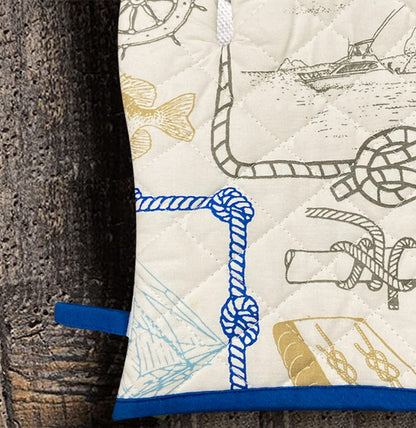 pair of white and blue oven gloves with a nautical pattern