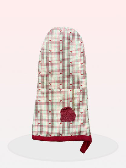 A white and red checkered oven glove with a small red heart-shaped detail on the side.