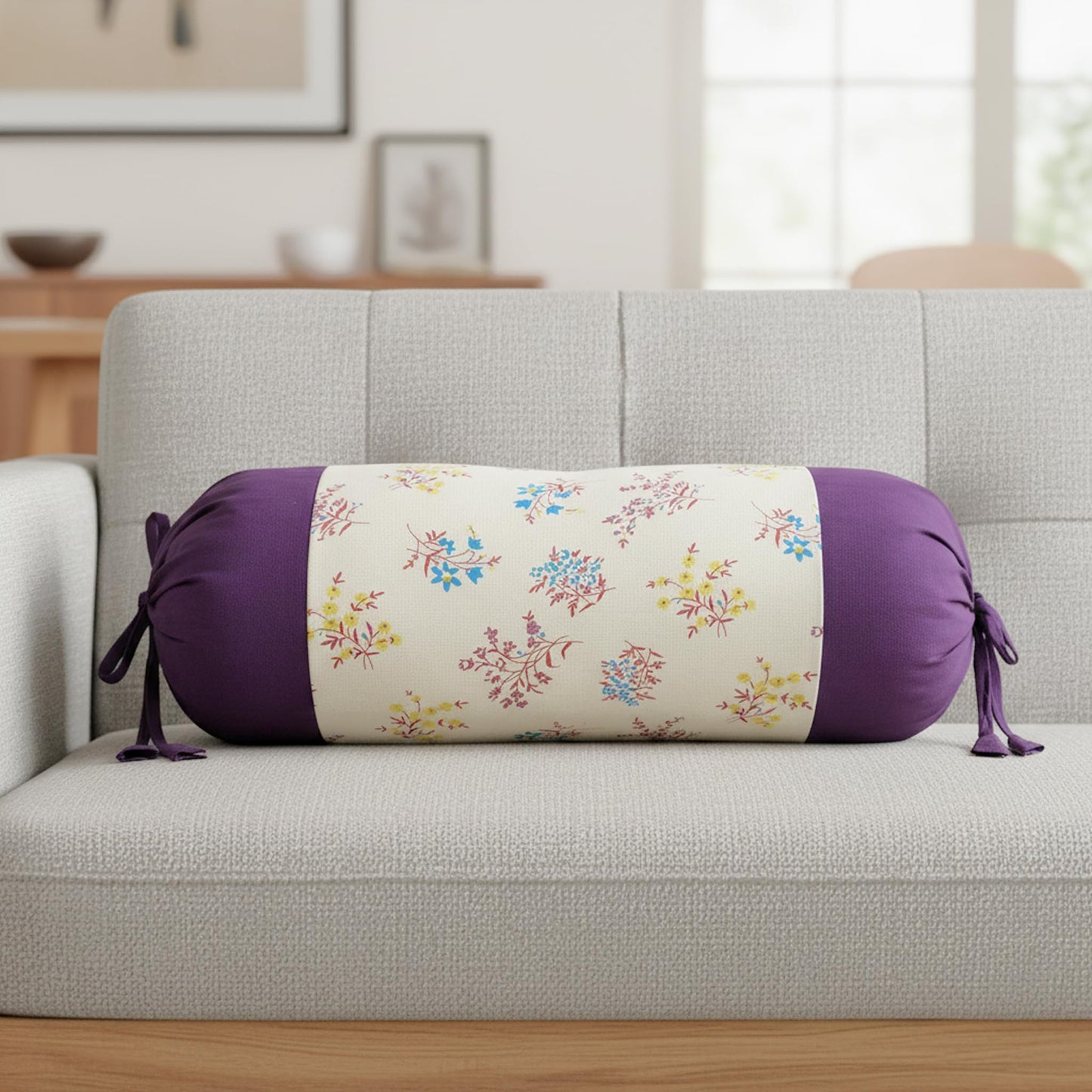Floral-patterned cylindrical pillow on a gray sofa in a living room setting