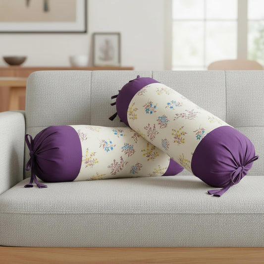 Floral cylindrical pillow with purple ends on a gray sofa in a living room setting.