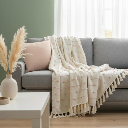 Gray sofa with a white textured blanket draped over it in a living room setting.