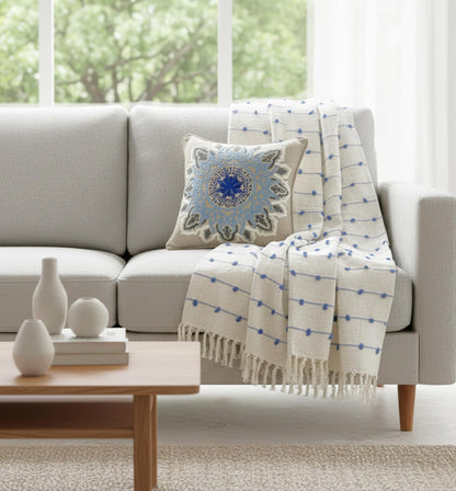 Gray sofa with decorative pillow and blanket in a living room setting