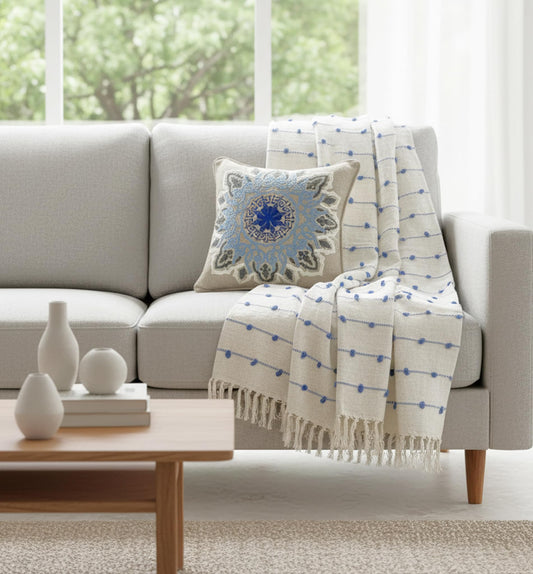 Gray sofa with decorative pillow and blanket in a living room setting