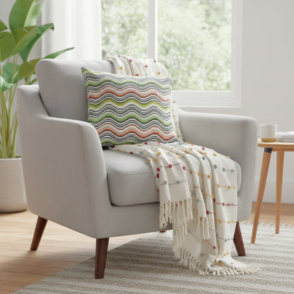 Gray armchair with a colorful pillow and blanket in a bright living room.